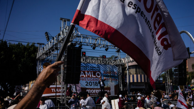 An attendee waves a party flag during a campaign rally with Andres Manuel Lopez Obrador, presidential candidate.