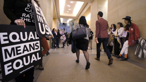 Supporters of the Equal Rights Amendment in Virginia, US, yell encouragement to two legislators as they walk down a hallway inside the state Capitol in Richmond in January.