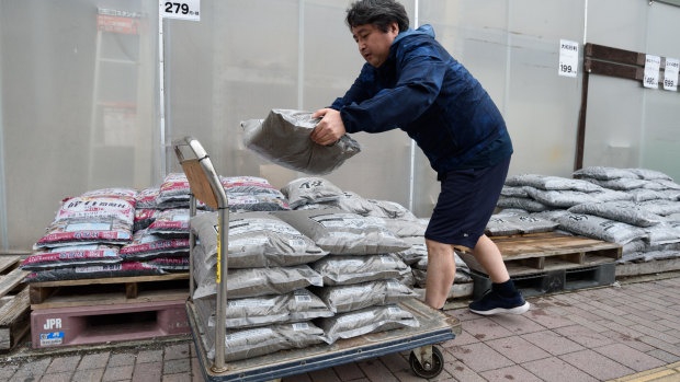 A customer loads sand bags at a hardware store in Kanagawa Prefecture. 
