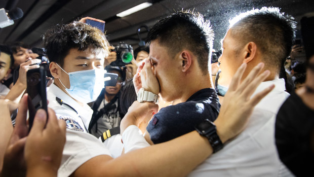 A man alleged to be a mainland police officer, centre, is surrounded by security officials and protesters at Hong Kong International Airport.