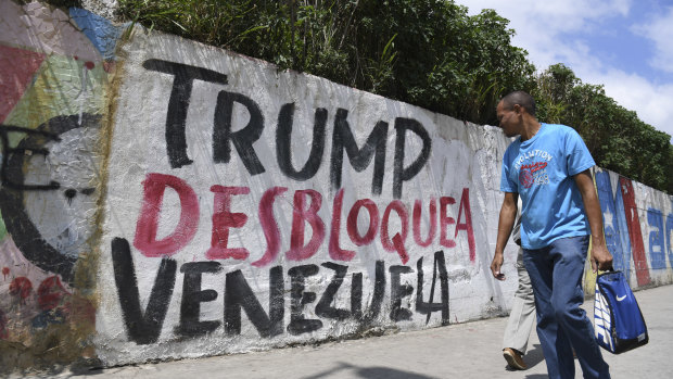 A pedestrian in Caracas passes graffiti protesting against US President Donald Trump's sanctions on Venezuela.