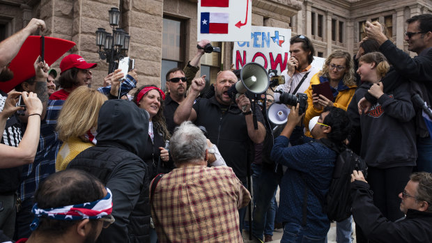 Alex Jones, radio host and creator of the website InfoWars, speaks into a megaphone as demonstrators gather outside the Texas State Capitol.