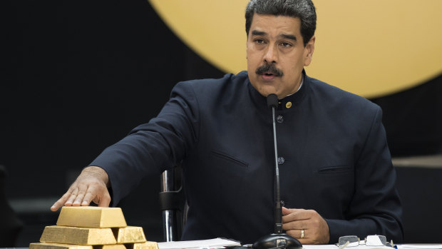 Venezuelan President Nicolas Maduro touches gold bars at a press conference  in Caracas in 2018.