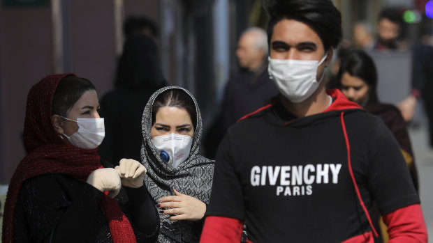Pedestrians wear masks to help guard against the Coronavirus, in downtown Tehran, Iran.