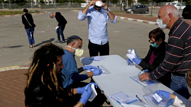 An inconclusive election: Israelis wore protective face masks to cast their votes at a special polling station set up for people quarantined for potential exposure to coronavirus in Ashkelon, Israel on March 2.