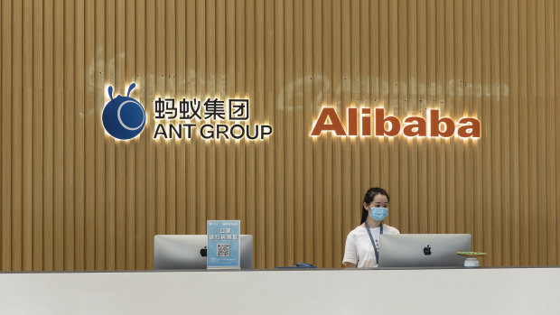 The Ant Group Co. logo and the Alibaba Group Holding Ltd. logo are displayed behind a reception desk at the company's headquarters in Hangzhou, China.