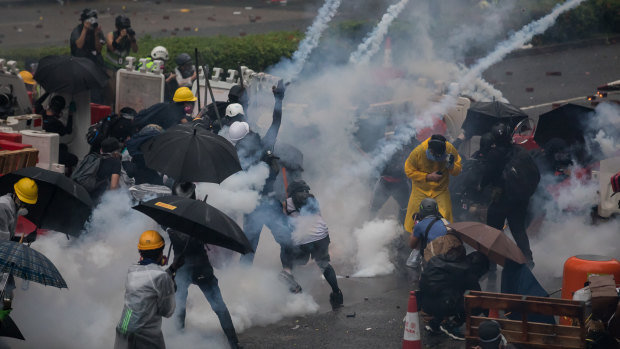 A world of conflict: Demonstrators react to tear gas during in the Tsuen Wan district of Hong Kong, China, as Beijing tightens its grip on the city's independence.