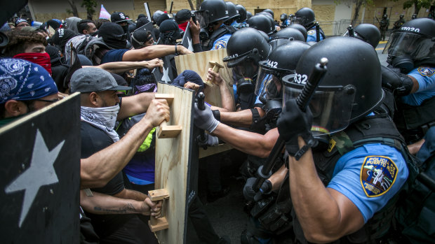 Demonstrators clash with riot police officers during a protest against austerity measures in San Juan, Puerto Rico.