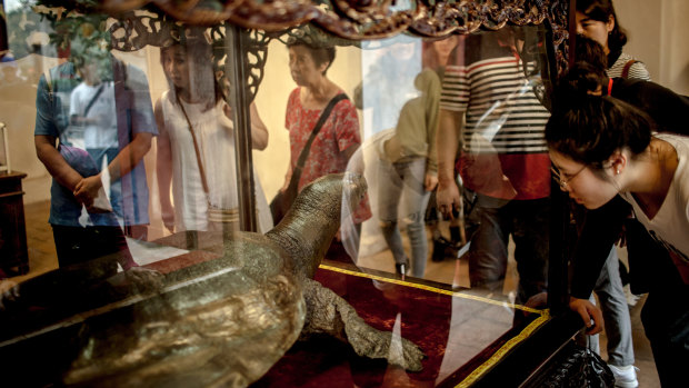 Visitors look at a statue of a turtle at the Ngoc Son Temple at Hoan Kiem lake in Hanoi, Vietnam, on Saturday.