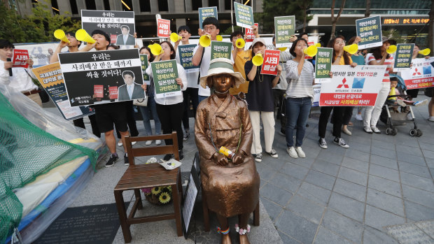 Students denounce Japan's exports control on South Korea, near a statue of a girl symbolising wartime "comfort women" in front of the Japanese embassy in Seoul.