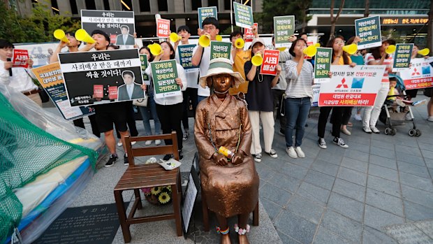 Students denounce Japan's exports control on South Korea, near a statue of a girl symbolising wartime "comfort women" in front of the Japanese embassy in Seoul.