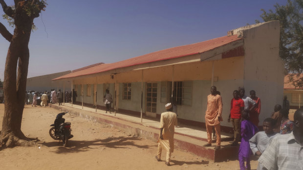 People gather inside the Government Science Secondary School in Kankara after the abductions.