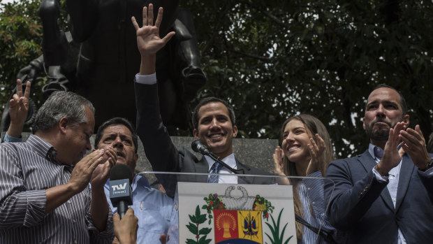 Juan Guaido, the president of the National Assembly who swore himself in as the leader of Venezuela, waves during a rally at Bolivar Square on Friday.
