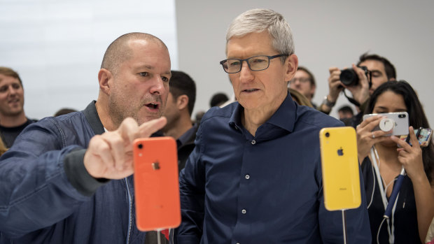 Jony Ive, chief design officer for Apple, left, and Tim Cook, chief executive officer, view a new iPhone during Apple's annual product event.