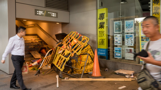 Barriers and other street furniture used by demonstrators sit in a pile at the bottom of a pedestrian overpass.