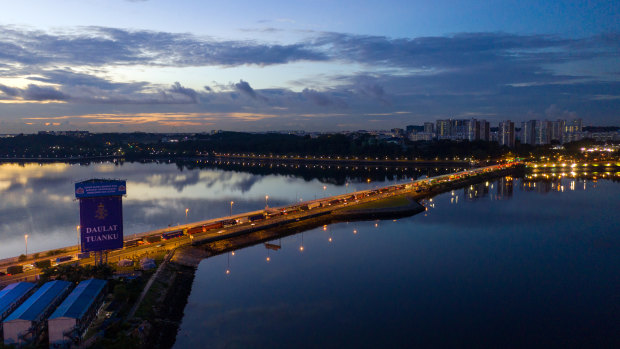 Commercial and residential buildings stand in Singapore, right, as vehicles travel along the Causeway across the Straits of Johor liking the island to Johor Bahru, Malaysia.