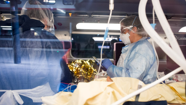 Medical personnel wearing personal protective equipment tend to a coronavirus patient on board a TGV high-speed train at a railway station in Paris, France.