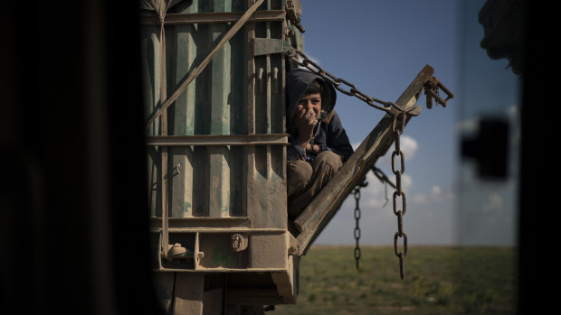 A boy rides in the back of a truck that is part of a convoy evacuating hundreds out of the last territory held by Islamic State militants, in Baghouz, eastern Syria, on Wednesday.