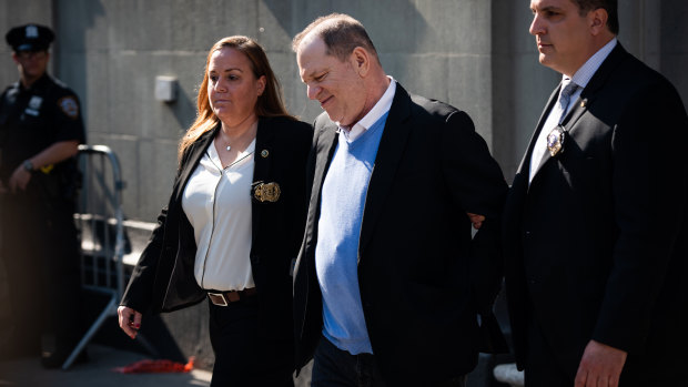 Charged: Harvey Weinstein is escorted in handcuffs out of the New York Police Department.