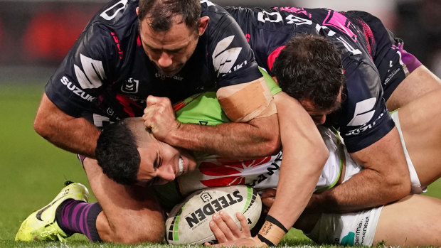 Cameron Smith appears to go to work on Canberra's Bailey Simonsson while pulling the jersey over his head.