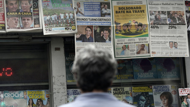 A man reads the headlines announcing the results of the Brazilian presidential election, in Rio de Janeiro.