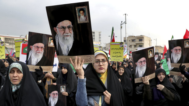 Demonstrators in Tehran hold up portraits of Supreme Leader Ayatollah Ali Khamenei during a pro-government rally denouncing last week’s violent protests over a fuel price hike.