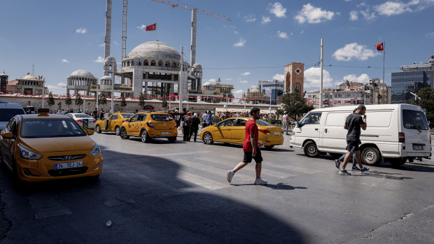 Pedestrians pass construction works at the Taksim mosque on Taksim Square in Istanbul.