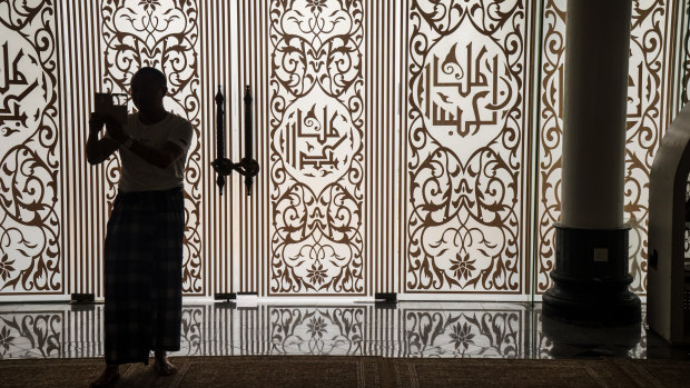A visitor is silhouetted at the Crystal Mosque in Kuala Terengganu, Terengganu, Malaysia. The country allows child marriages in some cases.