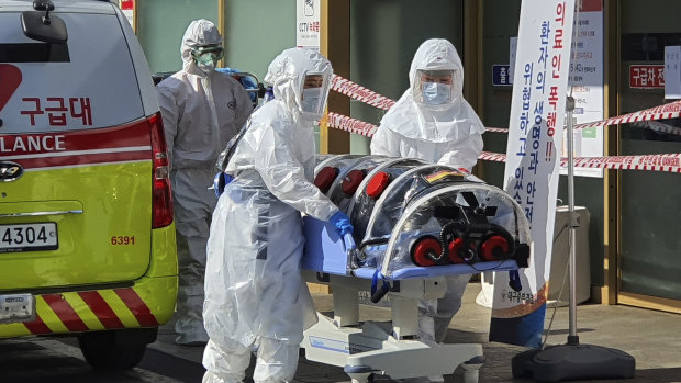 Medical workers move a patient suspected of having coronavirus from an ambulance to a hospital in Daegu, South Korea. 