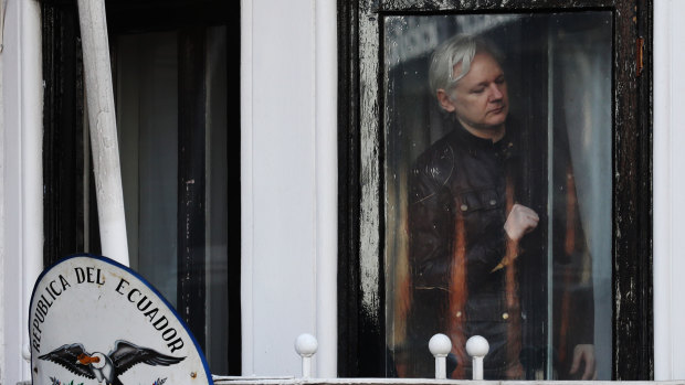 Julian Assange readies to open the door to a balcony to speak to media and supporters at the Ecuadorian embassy in London, last year.