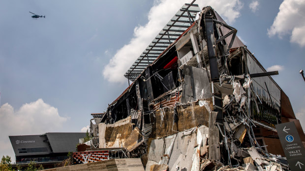 A helicopter flies above the collapsed section of the Artz Pedregal shopping mall in Mexico City.