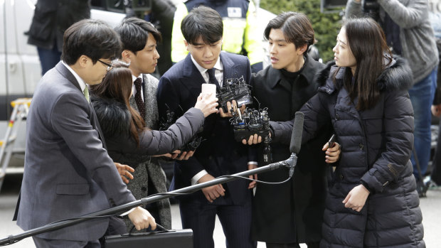 Seungri, centre, a member of a popular K-pop boy band Big Bang, arrives at the Seoul Metropolitan Police Agency on Thursday.