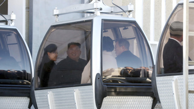 The two couples take a cable car to Mount Paektu in North Korea.