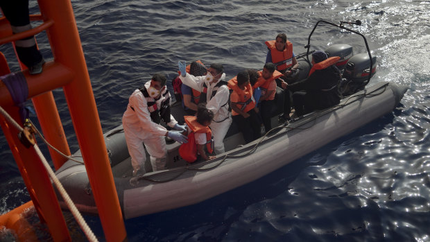 Maltese military personnel help children disembark from the Ocean Viking and board their rescue boat in the Mediterranean Sea last year, after Malta agreed to take 35 migrants fleeing Libya.