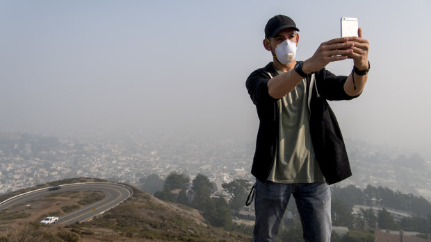 A tourist from San Diego takes a selfie as smoke from the Camp Fire fills the air in San Francisco, California,  on Friday.