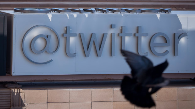 A bird flies past Twitter Inc. signage displayed outside the company's headquarters in San Francisco, California.