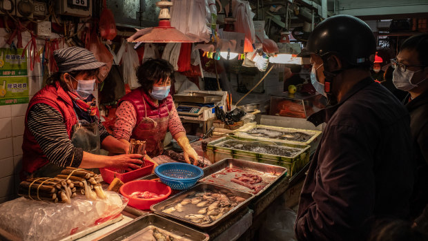 Residents wearing face masks buy seafood at a wet market in China.