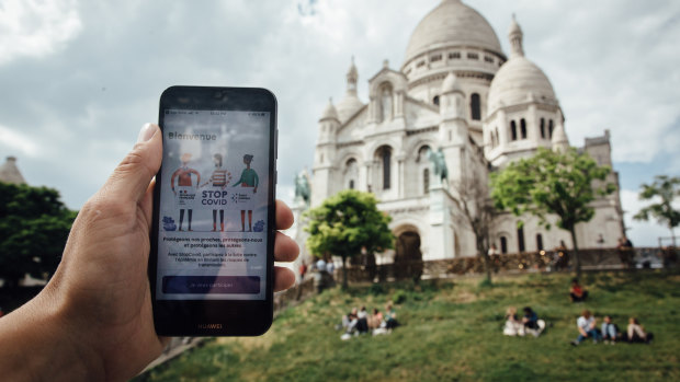 The StopCovid app is displayed on a smartphone near Sacre-Coeur basilica in this arranged photograph in Paris, France.