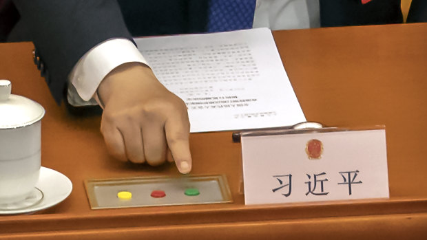 Chinese President Xi Jinping reaches to vote on an earlier piece of national security legislation concerning Hong Kong.