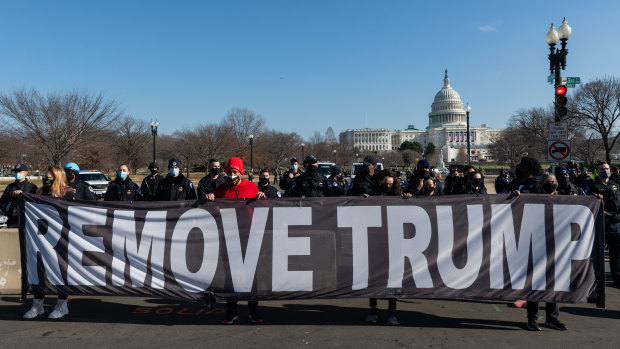 Demonstrators carry a "remove Trump" banner during a protest in Washington, DC,  on Wednesday, before US legislators voted for the second impeachment.