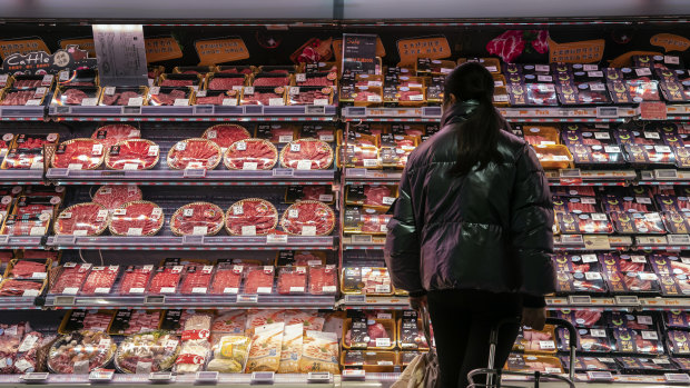 A customer looks at imported meat at an Ole supermarket, operated by China Resources Vanguard in Shanghai.