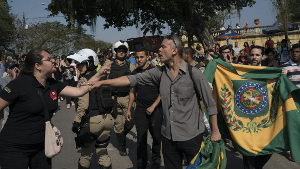 Supporters of Brazil's former monarchy, right, argue with people outside the ruins of National Museum in Rio.