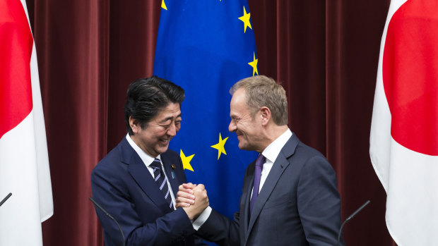 Japanese Prime Minister Shinzo Abe, left, shakes hands with EU President Donald Tusk, in Tokyo.
