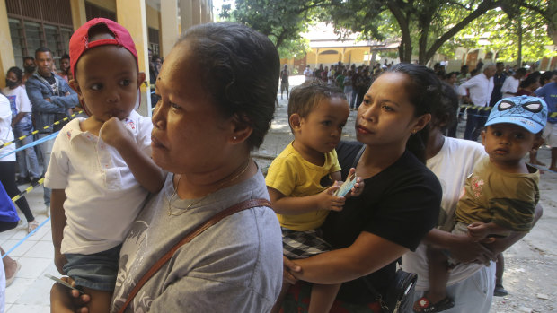 People queue up to cast their votes at a polling station in Dili.