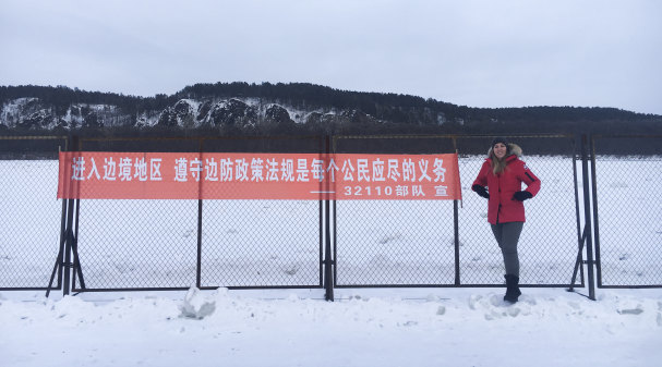 Cate Cadell at sign she says reads “Now entering the border area: complying with border policies and regulations is every citizen’s obligation.”