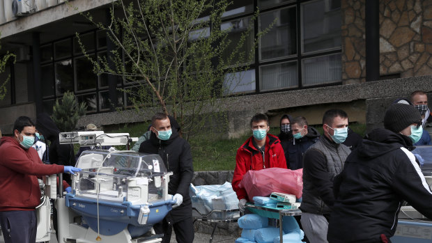 People carry incubators for newborn babies after a hospital had to be evacuated.