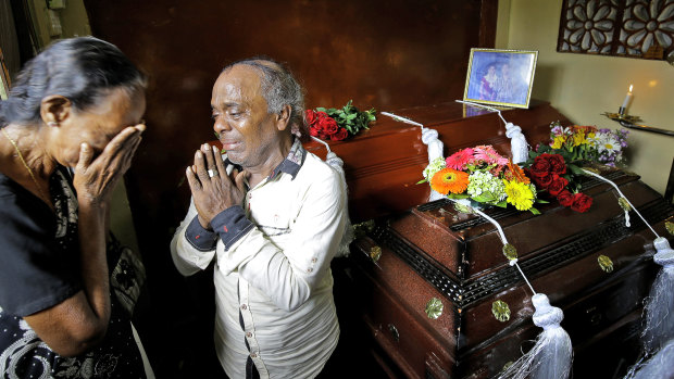 A Sri Lankan family mourns next to the coffins of their three family members, all victims of Easter Sunday bombings. 