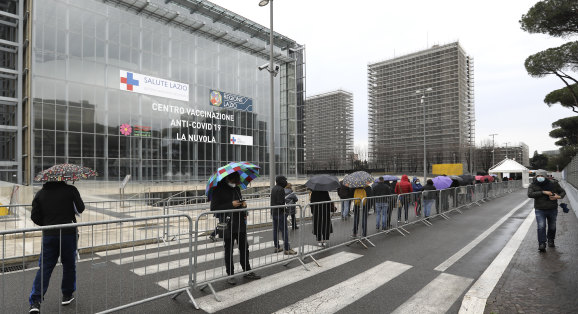 People stand in line at a COVID-19 vaccination centre in Rome as Prime Minister Mario Draghi faces a backlash over his country’s slow vaccination campaign.