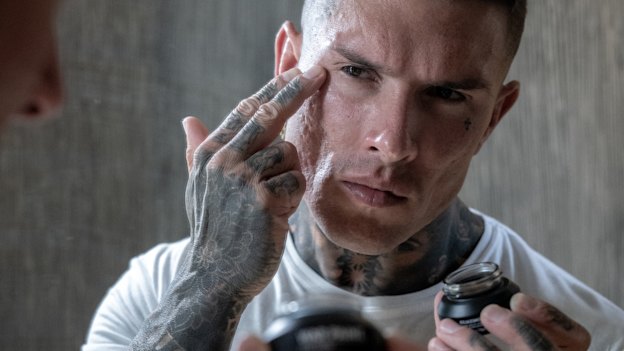 A model applying War Paint concealer. Make-up targeted at Australian men.