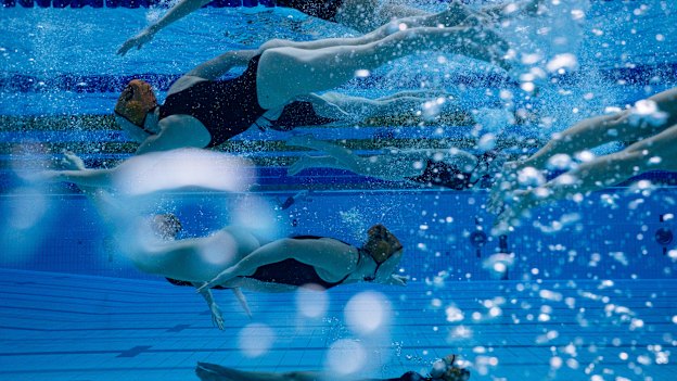 Balmain women’s water polo players stage a “swim-by” at the Australian National League Championships at the Sydney Olympic Park Aquatic Centre.